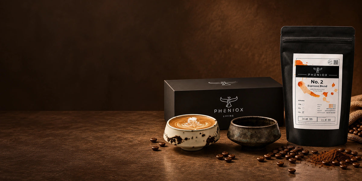 Zwei Barista-Tassen mit PHENIOX Geschenkbox und No.2 Espresso vor dunkelbraunem Hintergrund